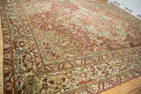 Distressed Baktiari carpet corner, faded burgundy and ivory motifs with visible foundation.