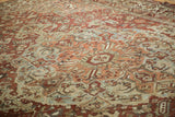 Distressed Baktiari carpet, dusty burgundy and powder blue blossoms and vines, even wear.