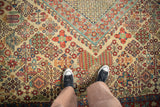 Intricate diamond lattice of a vintage Joshegan rug, featuring Four Seasons motifs and ivory, cherry red, jade green.
