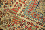 Vintage Joshegan carpet showcasing red floral clusters, green diamond lattice, and powder blue border.