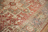 Distressed vintage Heriz geometric patterns with muted ruby and slate blue, showing softened pile.