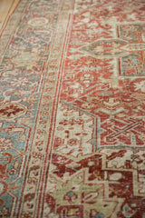 Distressed Heriz carpet border with ruby red, slate blue, and beige worn pile texture.