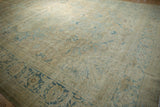 Vintage distressed Tabriz carpet close-up, faded blue floral arabesques, mostly even wear to knot heads.