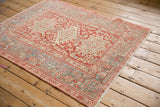 Angled perspective of the distressed Karaja rug's geometric medallions and wide, patterned borders.