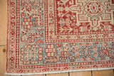 Corner of a vintage Karaja rug with a geometric border in red, slate blue, and sand tones.