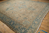 Distressed Heriz carpet corner with dusty blue Herati and turtle border, white fringe.