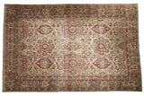 Antique distressed Kerman carpet with an allover floral medallion design in dusty red, sage, and ivory.