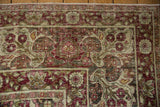 Worn pile on the floral and palmette border of a distressed antique Kerman carpet.