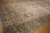 Angled perspective across the antique distressed Kerman carpet, showing its repeating floral bouquet medallions.