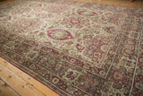 Intricate corner design of an antique Kerman carpet with dusty red and sage green floral vines.