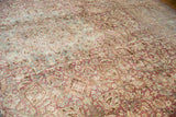 Heavy abrash creating a dynamic color shift on the distressed vintage rug's worn pile.