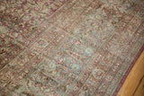 Low-pile texture of a distressed vintage rug showing intricate floral borders in raspberry and seafoam.