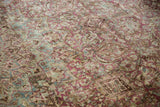 Heavy abrash and distressed texture on a vintage Persian carpet with raspberry and powder blue florals.