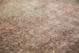 Angled view of the distressed texture and heavy abrash on a vintage Meshed carpet's floral field.