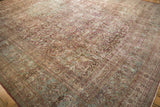 Time-softened raspberry and seafoam green tones across the intricate floral borders of a vintage Meshed carpet.