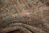 Intricate palmette and floral details on a softly draped, distressed vintage Persian carpet.