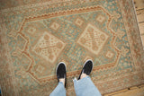 Distressed Afshar rug with geometric diamond pattern, showing even wear and soft hues.