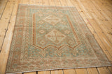 Distressed Afshar rug corner detail, with pale terra cotta borders and worn sky blue field.