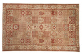 Distressed Persian Baktiari carpet with repeating garden panels in faded red, powder blue, and antique ivory.