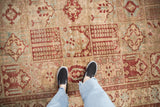 Low-pile texture and repeating panel design of a vintage distressed Baktiari carpet.