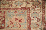 Meandering vine and pinwheel floral border in red on a distressed vintage Persian Baktiari carpet.