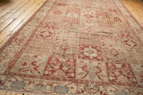 Angled view of a distressed Baktiari carpet's repeating Gardens of Paradise panel design.