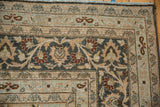 Corner detail of a vintage Persian carpet showing the meandering vine and palmette border.