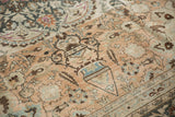 A traditional samovar lantern motif on a distressed Persian rug showing its low, textured pile.