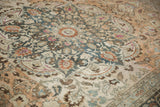 Close-up on the distressed wool pile and colorful starburst medallion of a vintage Persian carpet.