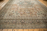 Low angle view of a vintage distressed Persian carpet's medallion and vine border.