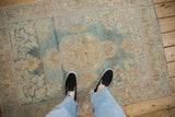 Distressed vintage Arak rug featuring an abrashed dusty blue field with faded floral patterns.