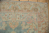 Vintage distressed Arak rug showing main border with dusty blue, rose, ivory floral arabesque.