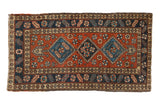 Vintage Heriz rug runner with a triple medallion in navy blue and beige over a dusty brick red field.