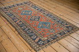 Vintage Heriz rug runner displaying its triple medallions on a dusty brick red field.
