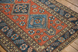 Arrowed shield finial and floral motifs on a vintage brick red and blue Heriz rug.