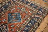 Angled view of a Heriz rug corner showing the serrated leaf main border and floral motifs.