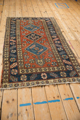 A vintage Persian Heriz runner showing the alignment of its triple geometric medallions.