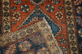 A folded corner of the vintage Heriz rug reveals its hand-knotted foundation and colorful pile.