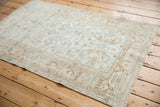 Ivory and dusty blue distressed Malayer rug with stretched turtle samovar border motif.