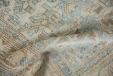 Distressed vintage Malayer rug, showing faded blue geometric patterns and unique turtle border.