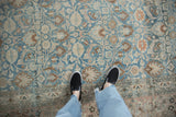 Distressed vintage Khorassan rug: dusty blue and ivory floral motifs on field and border.