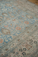Distressed vintage Khorassan rug's pale sapphire blue field with scrolling vines transitions to a floral main border.