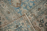 Distressed Khorassan carpet: faded blue floral motifs, hand-knotted pile texture, and woven reverse.