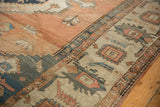 Wide floral cross-section border in dusty blue and beige on an antique Persian Serapi carpet.