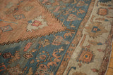 Wide banded main border with primitive motifs against the abrashed sandalwood field of an antique Serapi.