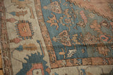 Wide ivory border with primitive rose and blue motifs revealing the low pile texture of an antique Serapi.