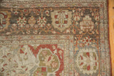 Corner detail of a distressed Farahan Sarouk showing the quarter map spandrel and floral borders.