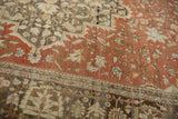 Time-softened wear on the rust floral vines and charcoal corner of an antique Persian carpet.
