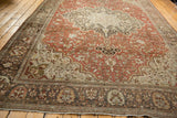 Antique Farahan Sarouk carpet's rust field and large medallion viewed from a corner angle.