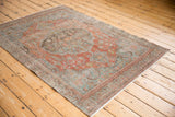 Faded terracotta and slate blue hues with distressed texture on Malayer rug field.